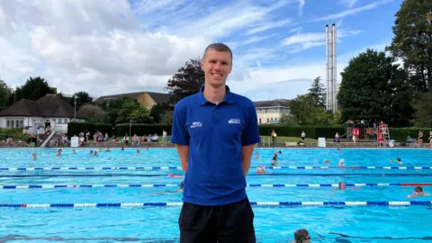 bbc Man standing in front of outdoor swimming pool