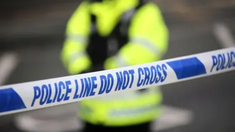 Generic image of a police cordon with an officer in high vis pictured in the background