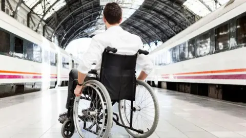 Getty Images Man waits for train in wheelchair