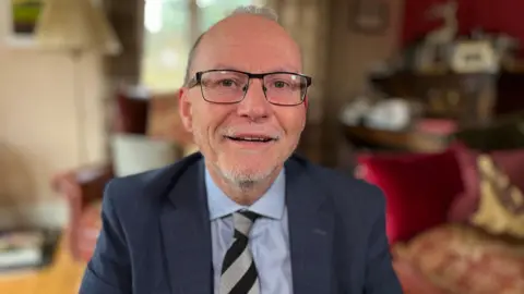 Martin Giles/BBC Cambridgeshire NASUWT Secretary Adrian Miller smiling.