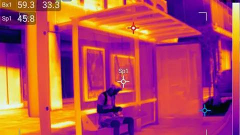Greenpeace / TI Thermal Imaging Thermal image of a man at a bus stop. 