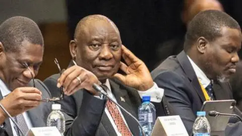 AFP Deputy president of the African National Congress (ANC) Paul Mashatile (L) and president of the African National Congress (ANC) and South African President Cyril Ramaphosa (2nd L) attend the first sitting of the New South African Parliament in Cape Town on  14 June.