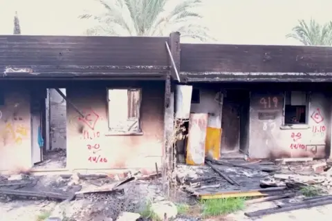 Reuters Burnt-out houses with spray painted markings