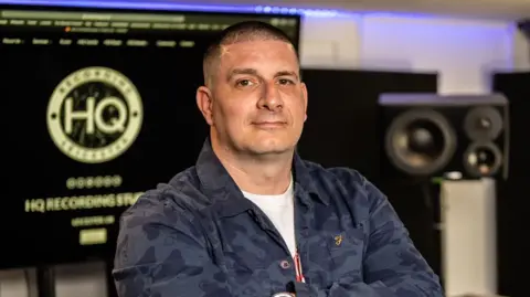 Leicester City Council Man with studio speaker and blurred background and folded arms looking into camera