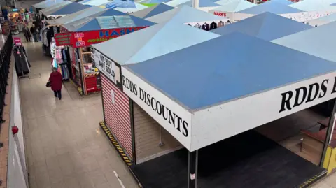 Looking down at quiet market stalls with blue pointed roofs.