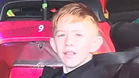 Kory McCrimmon is looking directly at the camera. He is a young teenage boy with red hair. 