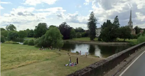 Google image of Wallingford beach with a church and greenery in the background.