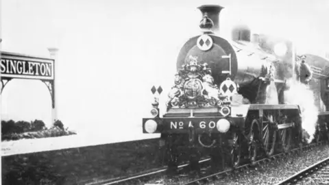 Middleton Press A steam train at the old Singleton station. The image is in black and white.
