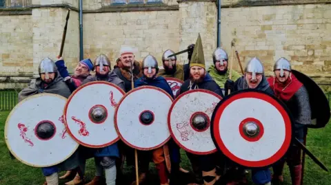 Handout A group of men in Viking armour and helmets hold up circular shields towards the camera