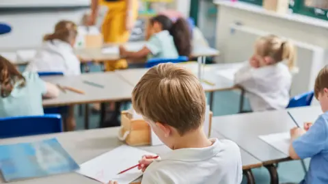 Getty Images Young children in a classroom are working on schoolwork