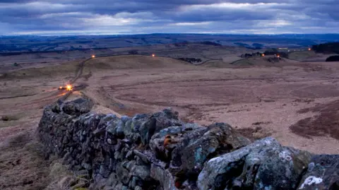 Getty Images A panoramic view of Hadrian's Wall with beacons lit at points along stretching several miles 