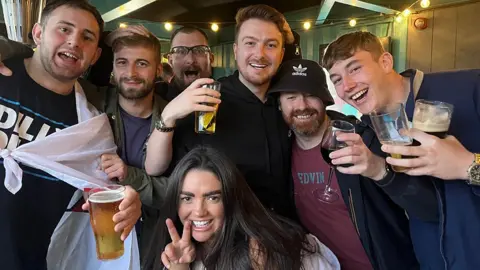 Kieran, Andy, Chris and Phoebe (and some stragglers) pose with drinks in hand