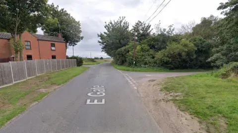 A Google images screengrab of the junction of Eastgate and Hagbeach Gate, Whaplode. There are trees, fields and a house at the side of the road.