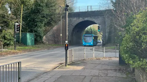 A bridge with a bus passing underneath.