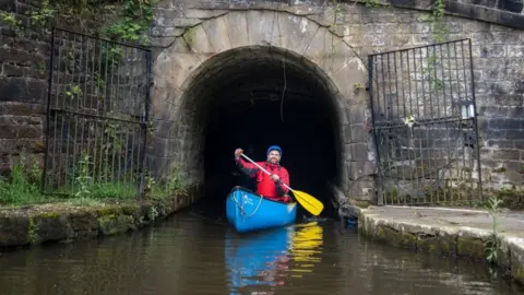 Danny Lawson/PA Wire Man paddling out of Standedge Tunnel