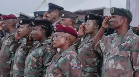 An image of South African soldiers wearing camouflage saluting 