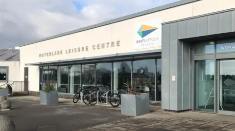 Steve Silk/BBC A general view of the entrance into Waterlane Leisure Centre. The centre's name is written on the building along with the East Suffolk Council's logo. Bicycles are parked in a wrack outside the building.