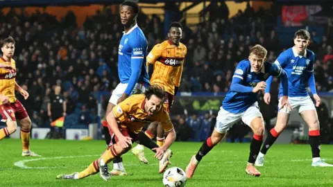 Motherwell's Lukas Fadinger goes down under a challenge from Rangers Emmanuel Fernandez 