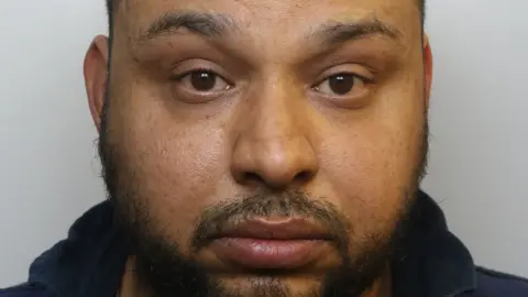 Avon and Somerset Police A man staring at the camera in a police mugshot with a beard