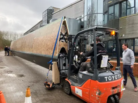 The blade being manoeuvred into position at the factory site