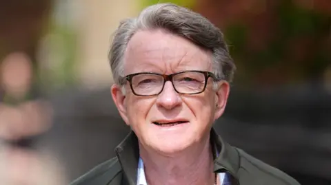 PA Media Peter Mandelson has short greying hair and wears dark glasses. He wears a shirt, grey jacket and appears to be outside