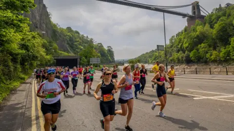 THE AJ BELL GREAT BRISTOL RUN Runners running under the Clifton Suspension Bridge in Bristol 