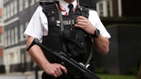 PA Media Close-up of a Met Police officer holding a firearm