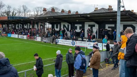 Getty Images Supporters at Maidenhead United stadium, with a stand painted black and white with Maidenhead United painted on it 