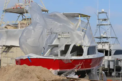 Doris Enders A plastic cover on a ship in dock blows in the wind