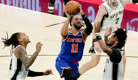 New York Knicks guard Jalen Brunson (11) shoots against San Antonio Spurs guard Stephon Castle (5) in the first half during game five of the 2026 NBA Finals in Texas.