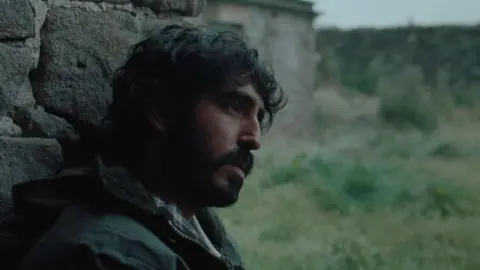 MAB Rabbit Ltd 2024 A man sat against a wall staring ahead 