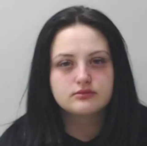 Police Scotland A mugshot of a young woman with long dark hair. 