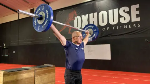 Bernard Trybull holding a barbell above his head