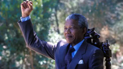 PA Media A man with white hair punching the air