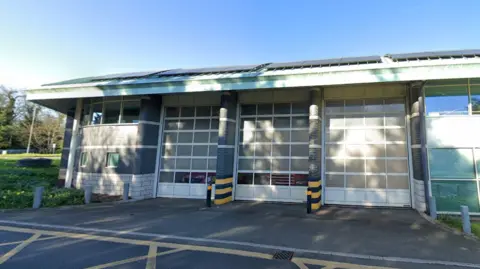 Google The outside of Marlow Fire Station. The shutter doors are down, and there are solar panels on the roof