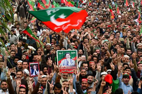 گتی ایماژ جمعیت بزرگی پرچم ها و پلاکاردها را در حمایت از عمران خان تکان می دهند