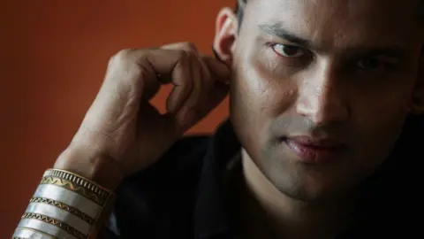 Getty Images Zubeen Garg, sporting a black tee shirt and a metallic calf bracelet, poses for the camera in 2008