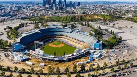 A view of Dodgers Stadium with the Los Angeles skyline in the background