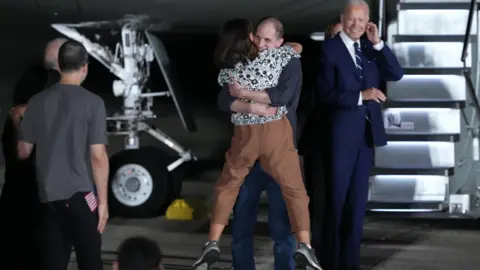 Getty Images US President Joe Biden watched on as Evan Gershkovich gave his mother Ella Milman a huge hug after disembarking at Joint Base Andrews