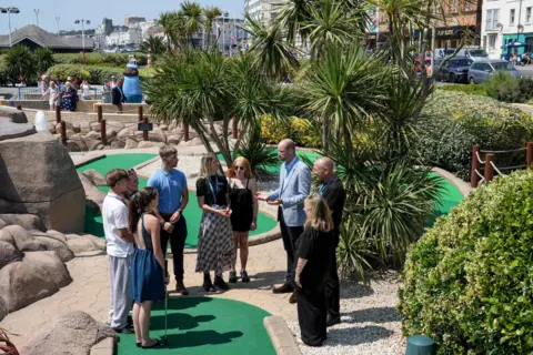 Carlos Jasso/REUTERS Prince William stands in a group of people on a crazy golf course