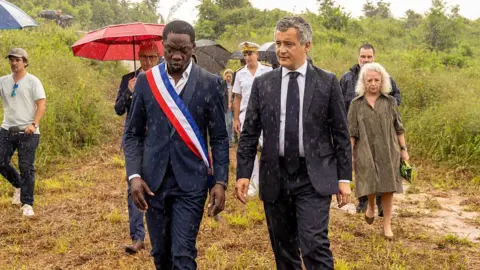 Getty Images Gérald Darmanin walking through the Amazon rainforest