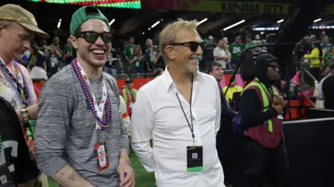 Reuters Actors Pete Davidson and Kevin Costner were spotted sharing a laugh ahead of the game kicking off