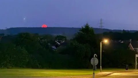 DRob Moon on horizon. It is just peaking above a hill in the distance
