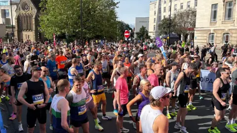 A crowd of people in running gear ahead of the race starting