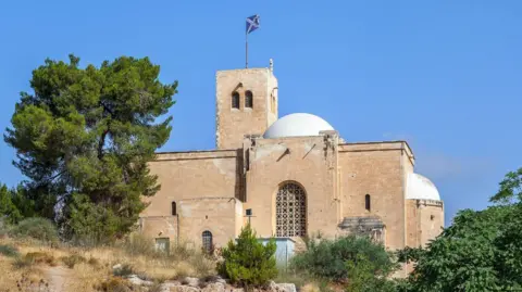 A church building, mostly sandstone, with a Scottish flag at the top 