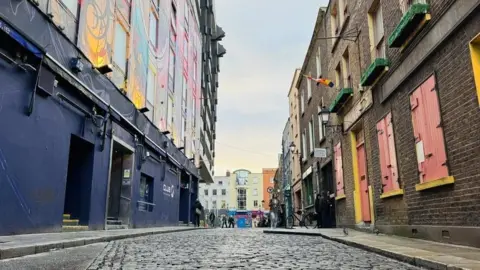 Dublin's Cope Street, which has a blue building on the left and a brown building with pink shutters on the right.