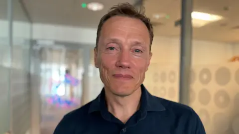 Iain Foulkes in corridor at Cancer Research UK