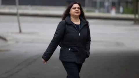 Gareth Everett/Huw Evans Picture Agency Tanya Nasir walking across road to court in black coat