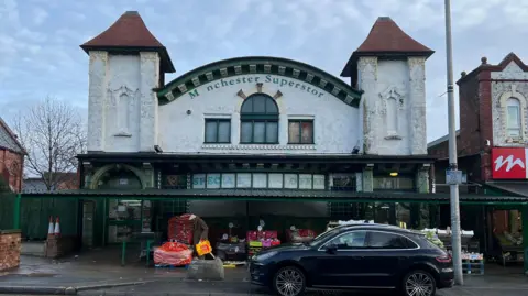 A view of Manchester Superstore, a former temperance billiard hall on Cheetham Hill Road in Manchester. The image is of the front of the building and shows the domed roof.