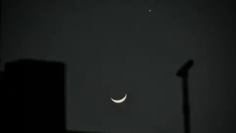 Getty Images Venus appears beside a crescent moon in the night sky in Kolkata, India.